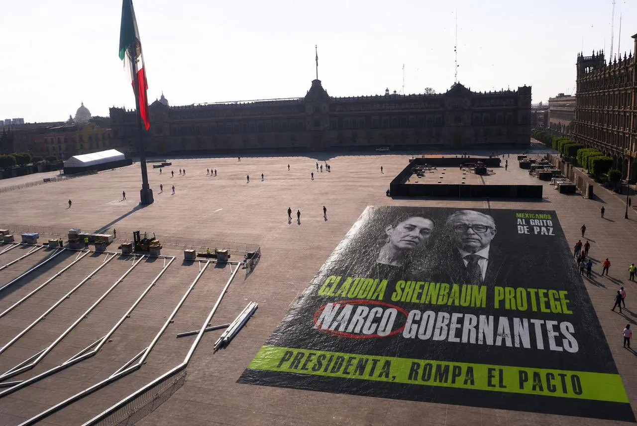 "Claudia Sheinbaum protege a narcogobernantes"; colectivo instala lona frente a Palacio Nacional y "reventadores" la retiran